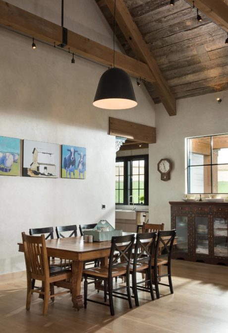 Rustic dining space with wooden beams and large pendant light.