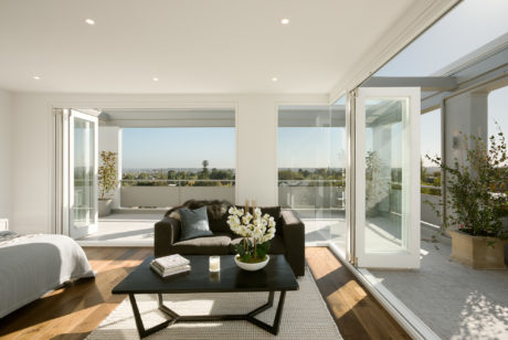 Spacious living room with large windows, glass doors, and a modern, open-plan design.