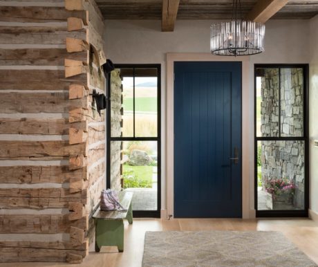 Rustic entryway with a blue door, wooden and stone walls, and