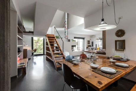 Bright, open-concept living space with rustic wooden table and modern accents.