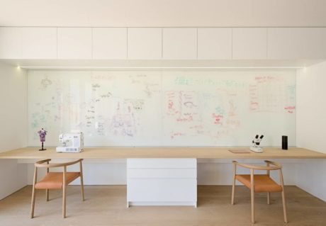 Minimalist home office with a clear scribbled wall, wooden desk, and