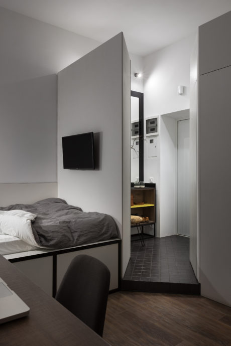 Minimalist bedroom design with muted colors, recessed lighting, and modern furniture.