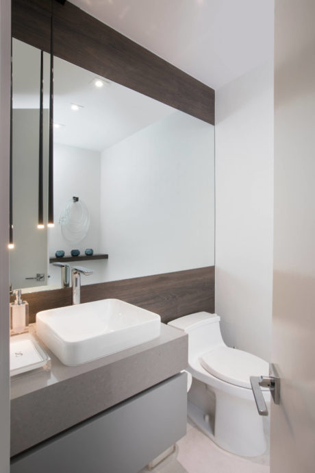 A modern bathroom with a sleek, minimalist design featuring a dark wood vanity and a white vessel sink.