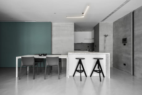 Modern minimalist interior with marble-topped kitchen island, sleek grey chairs, and neutral color palette.