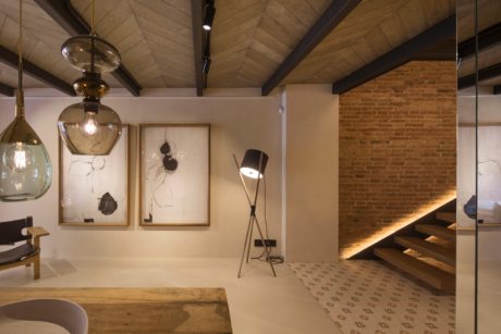 A cozy, modern space with exposed brick walls, wooden beams, and unique lighting fixtures.