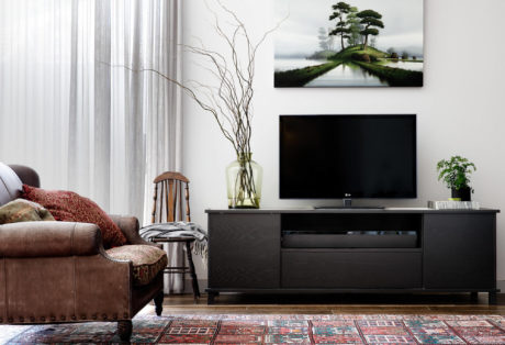 Cozy living room with rustic furniture, TV console, and decorative accents evoking a warm, inviting ambiance.