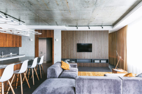 Striking industrial-style interior with wood paneling, concrete ceiling, and modern furnishings.
