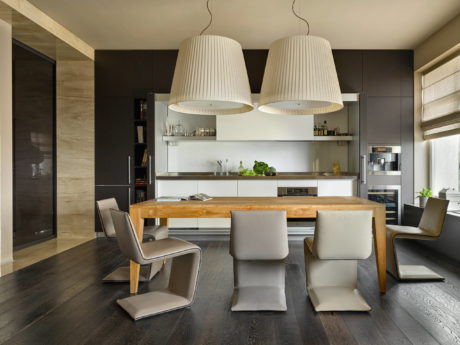 Sleek kitchen with wooden island, pendant lights, and contemporary furnishings.