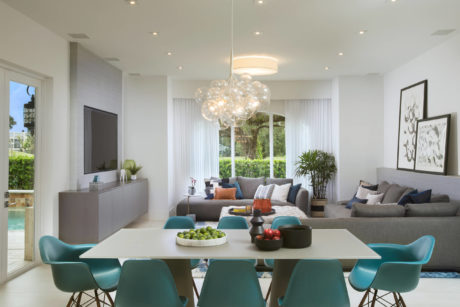 Modern open-concept living room with sleek furniture, vibrant accents, and abundant natural light.