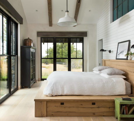 Rustic-chic bedroom with wooden bed and large windows