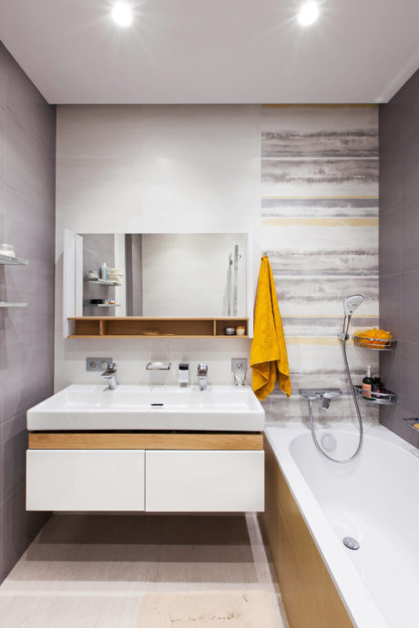 Elegant bathroom design with minimalist vanity, open shelving, and a vibrant yellow towel.
