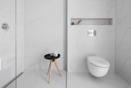 Sleek bathroom design featuring minimalist vanity, recessed shelf, and clean-lined toilet.