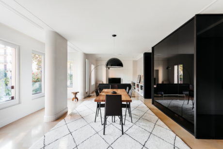 Contemporary dining space with monochrome accents and large windows.