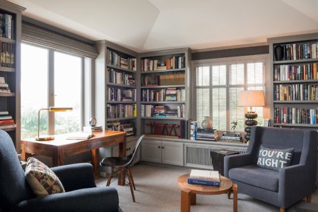 Cozy home study with bookshelves, a desk, and comfortable seating.