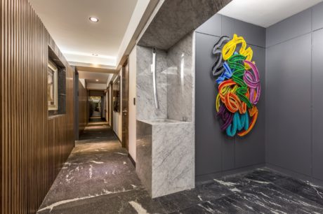 Modern hallway with marble features and colorful wall art.