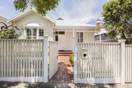 Charming white picket-fenced house with a traditional design.