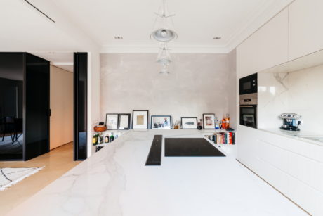Sleek kitchen with marble countertop and framed photos.