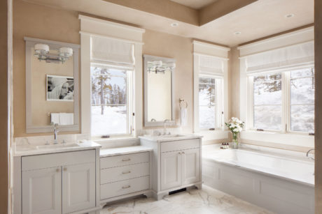 Bright bathroom interior with dual vanity sinks, large windows, and a bathtub.