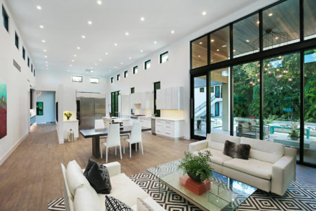 Contemporary living space with abundant lighting and large windows.