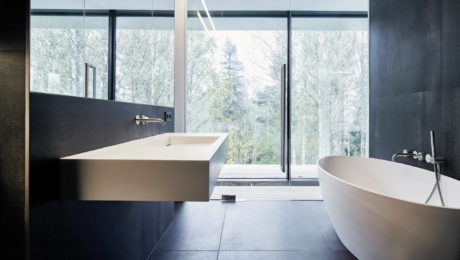 Modern bathroom with large window and forest view.