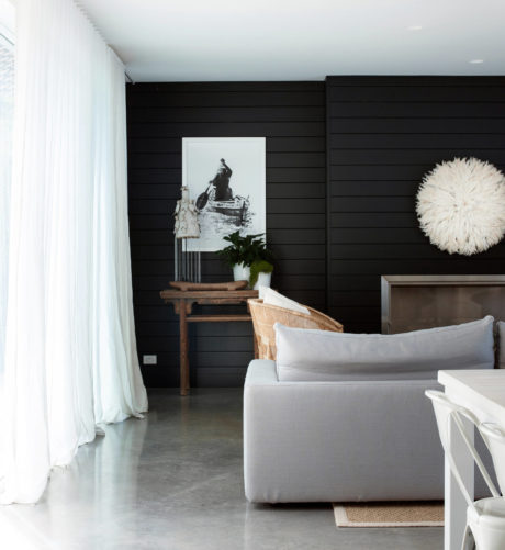 Modern room with black wall, white decor, and a framed artwork.
