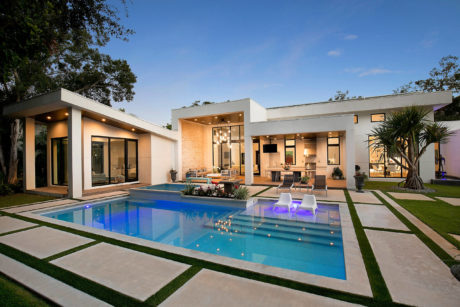 Modern house with pool and open patio at dusk.