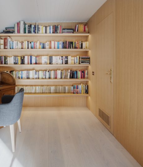 Scandinavian-style interior with a wooden bookshelf and matching door.