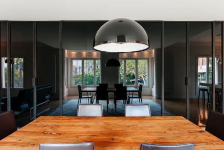 Modern dining room with a large wooden table and a dome-shaped pendant light.