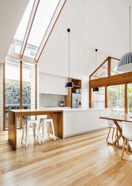 Modern kitchen with high ceilings, skylights, and a mix of white and