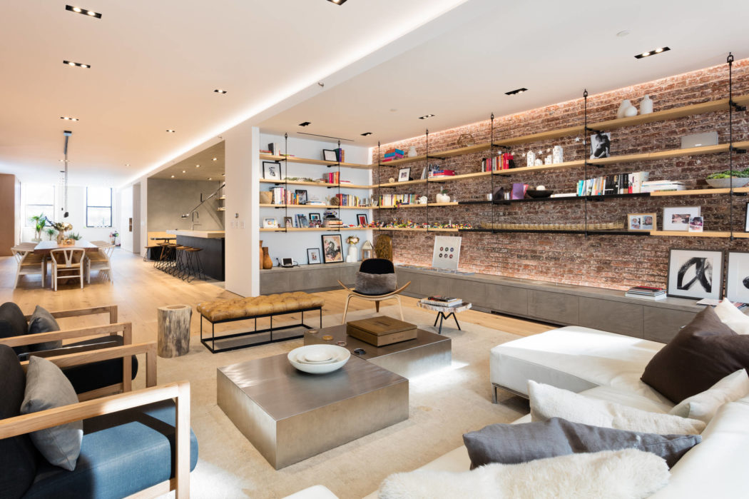 Modern living room with exposed brick wall and open shelving.