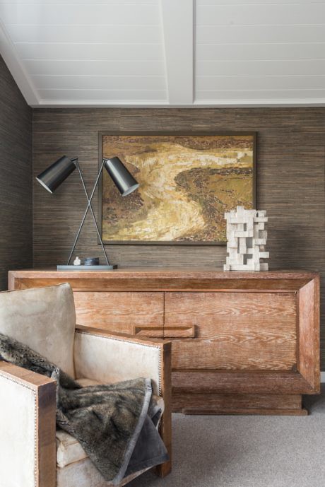 Contemporary study corner with wooden desk, armchair, and abstract art.
