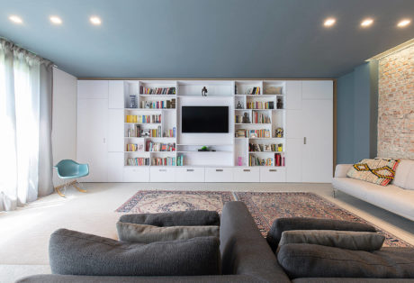 Contemporary living room with expansive bookshelf wall and cozy seating.