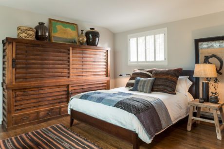 Contemporary bedroom with wooden furniture and neutral tones.