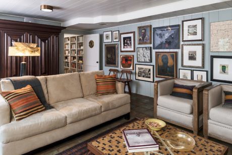 Cozy living room with sofa, chairs, and gallery wall of framed art.
