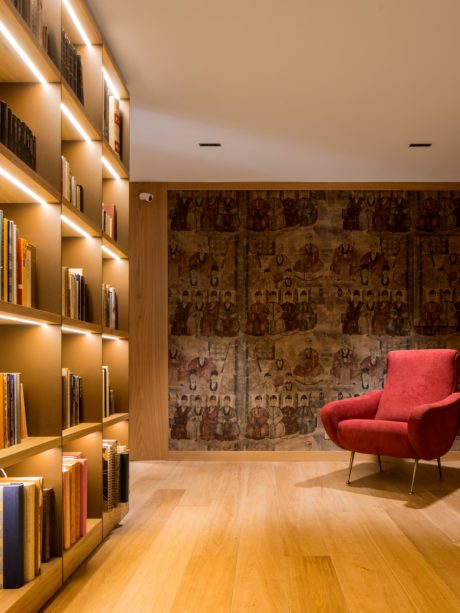 Cozy home library corner with floor-to-ceiling bookshelves and a red