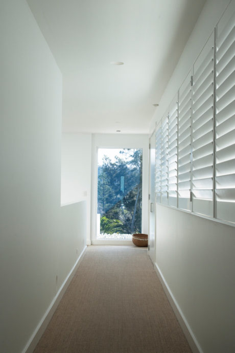 Bright, minimalist hallway with large windows and neutral tones.