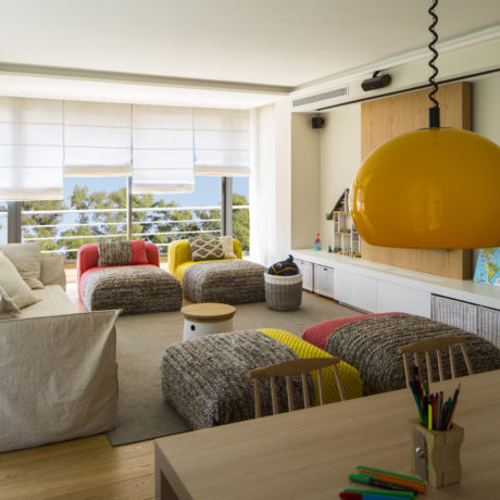 Modern living room with colorful furniture and ocean view.