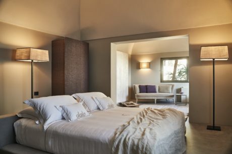 Contemporary bedroom with neutral tones and elegant lighting.