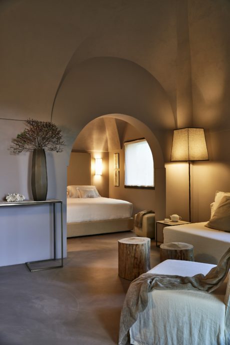 Elegant bedroom with arched ceiling, soft lighting, and modern decor.