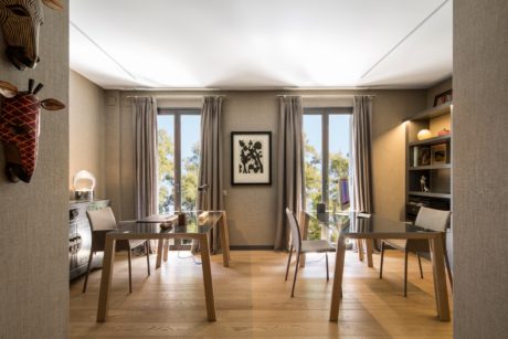 Modern dining room with wooden furniture and large windows.
