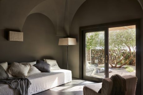 Contemporary bedroom with arched ceiling and large window.
