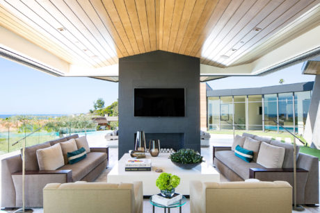 Contemporary living room with a sleek fireplace, vaulted ceiling, and ocean view