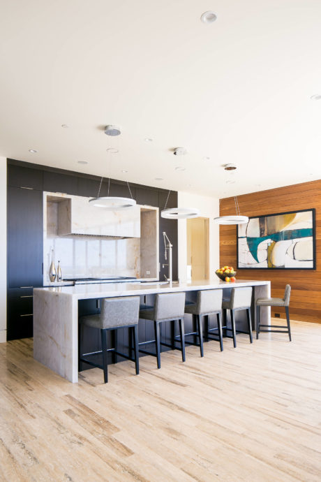 Modern kitchen with bar seating and wooden floors.