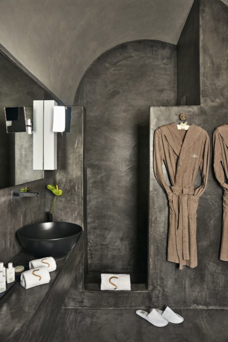 Contemporary bathroom with dark walls and round basin.