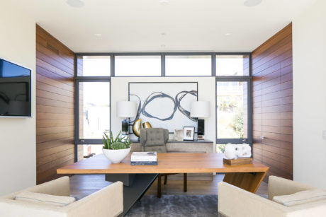 Contemporary living room with wooden panel walls and minimalist decor.
