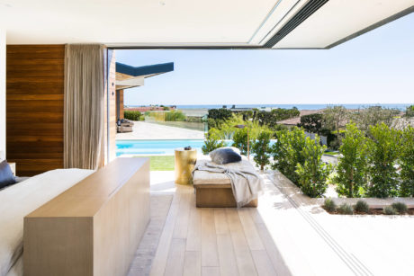 Modern room opening up to a poolside area with a clear view of the sky