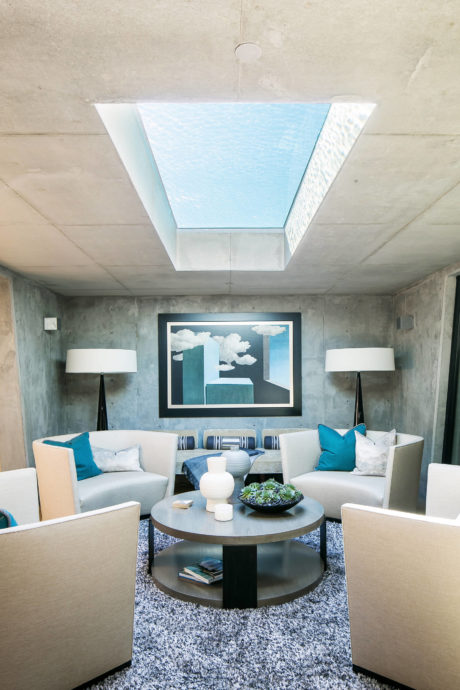 Chic lounge with skylight pool view and minimalist decor.