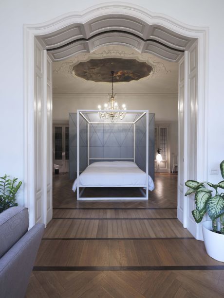 Elegant bedroom with a four-poster bed, ornate ceiling, and a