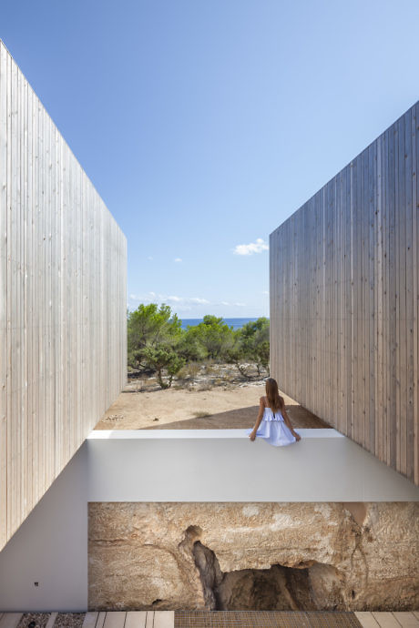 Minimalist courtyard with wooden slat walls and a girl gazing out.