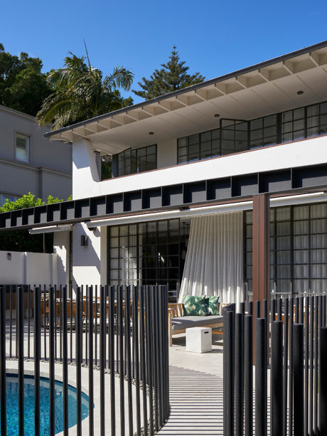 Contemporary two-story home with pool and vertical fence.